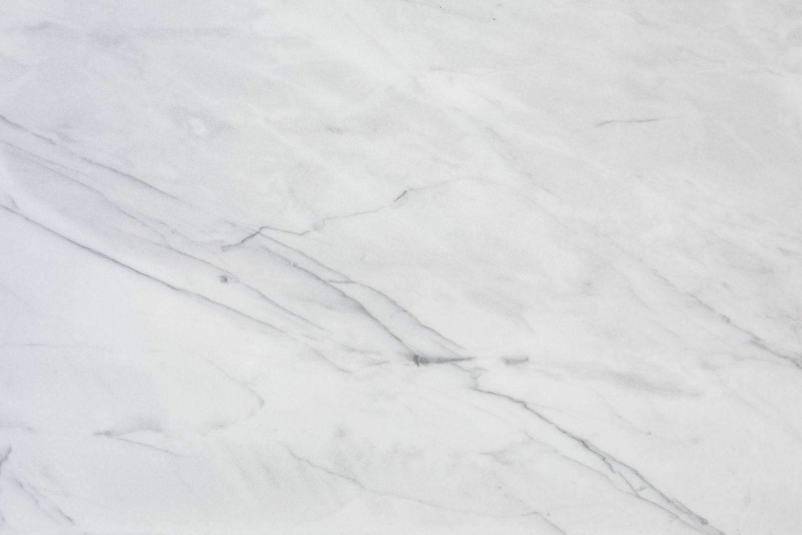 Close-up of elegant white marble texture with natural veining and subtle cracks.